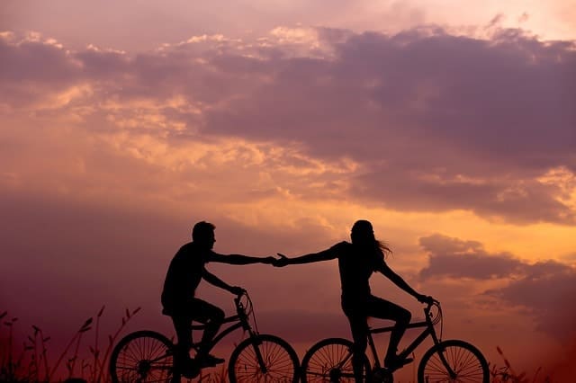 muž a žena na kole při západu slunce