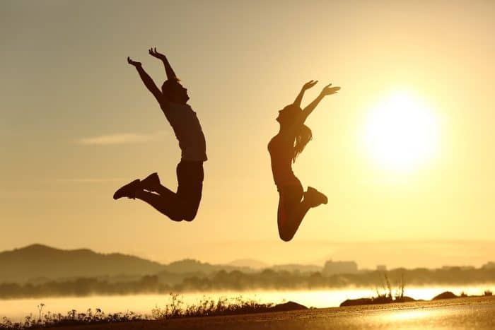 obrázek dvou lidí skákajících za jasného slunce